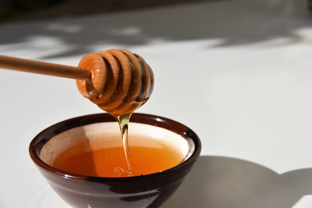 honey for dogs, bowl of honey dripping from a utinsil