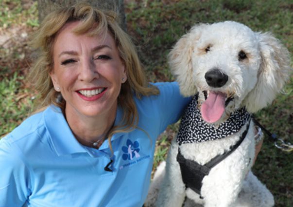 Dr. Alexa Diaz, Ph.D teaches a dog training class just like she trains service dogs, with her white doodle